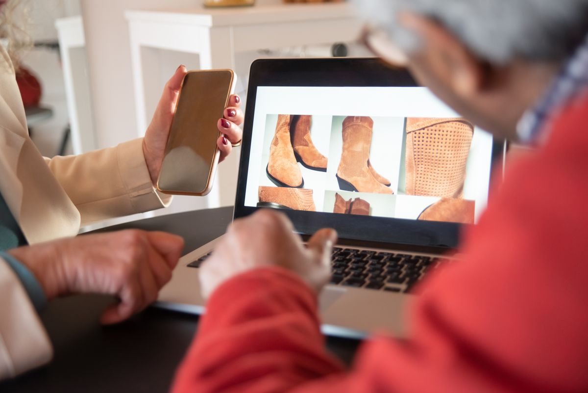 Two people looking at an online store together on a laptop and smartphone at home
