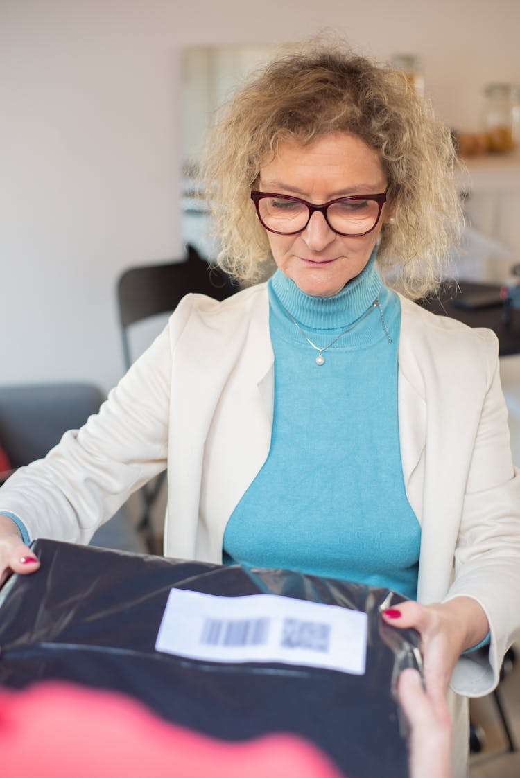 Photograph Of A Woman With Eyeglasses Receiving A Parcel