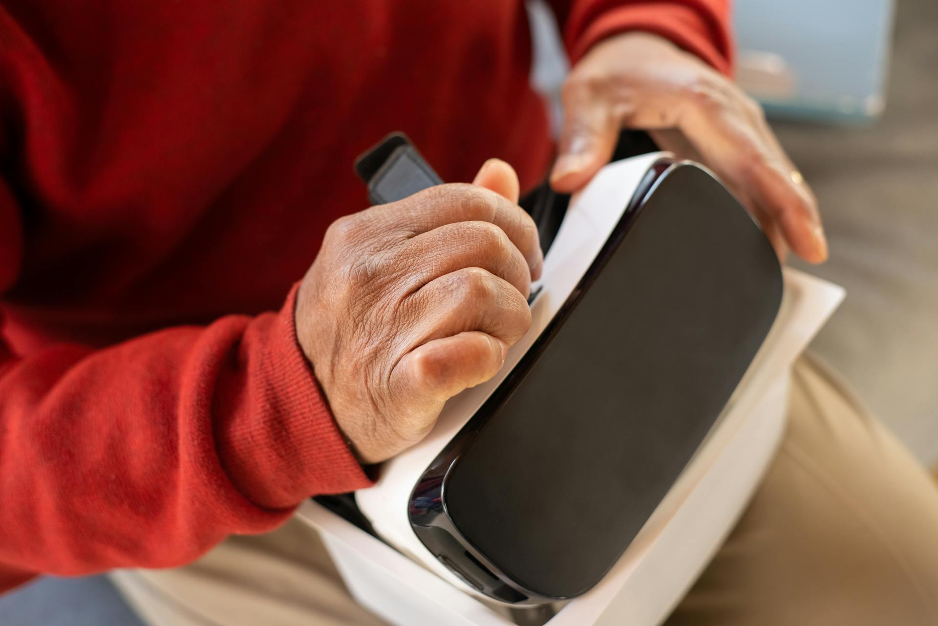 Close-up of adult hands setting up VR headset, emphasizing virtual technology interaction.