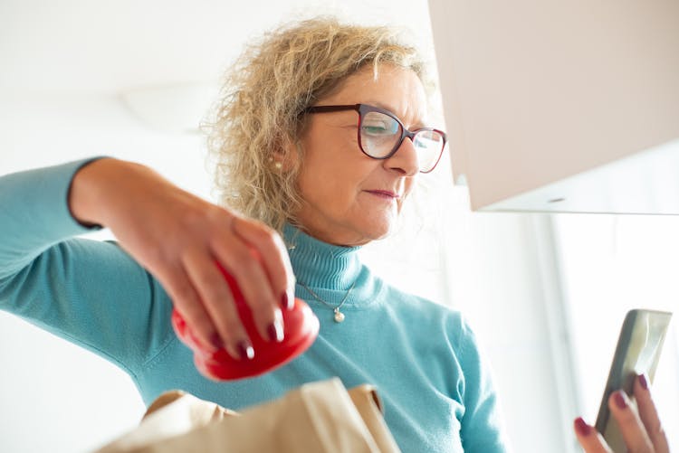 Photograph Of An Elderly Woman With Eyeglasses Looking At Her Cell Phone