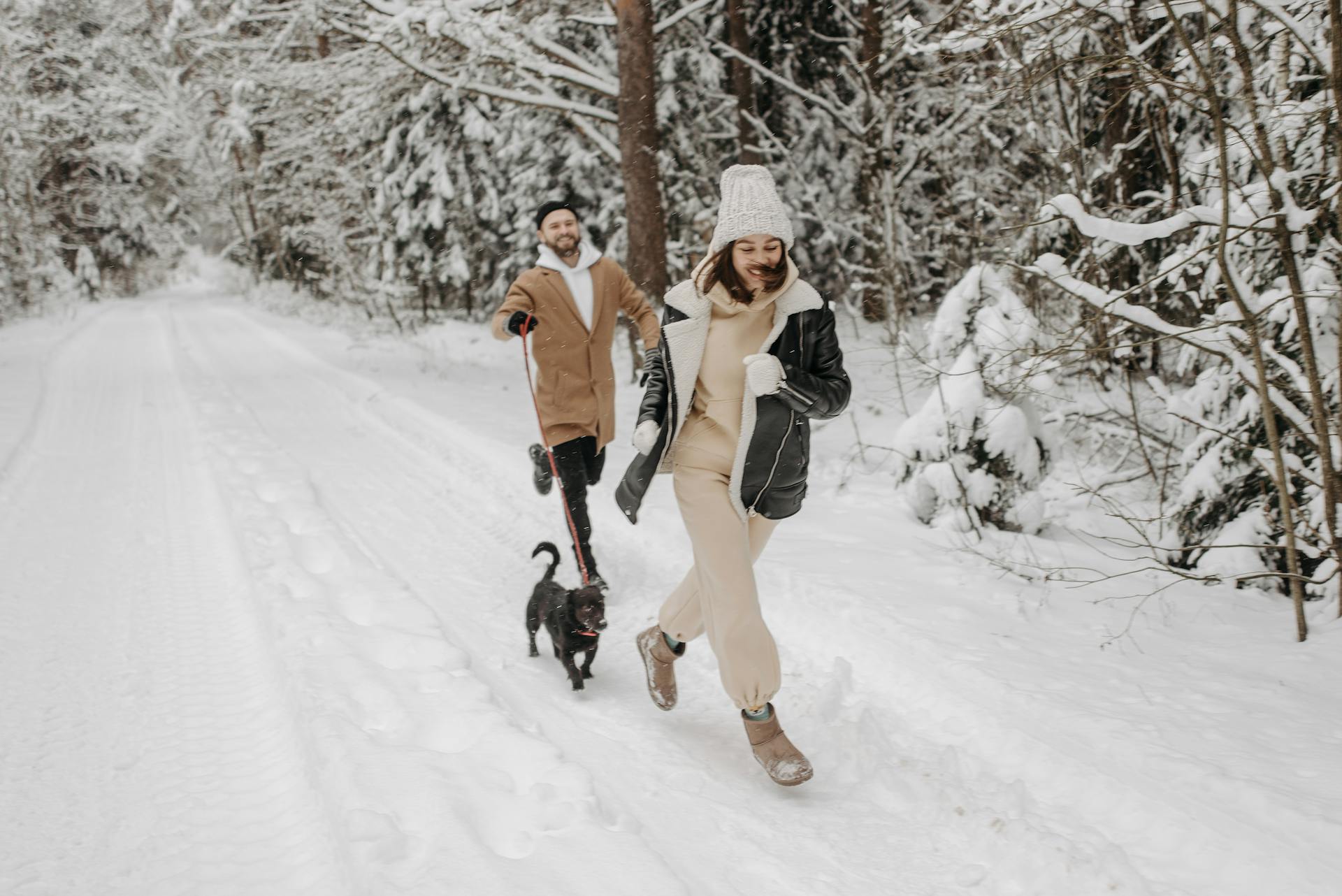 Photograph of a Couple Running with Their Pet