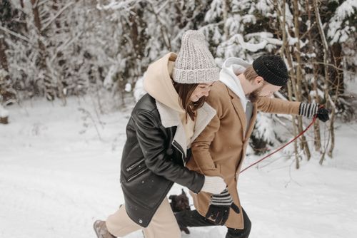 Free Happy couple walking in the snow, sharing warmth and laughter in a winter wonderland. Stock Photo
