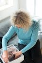 Woman in Blue Long Sleeve Shirt Sitting on Couch