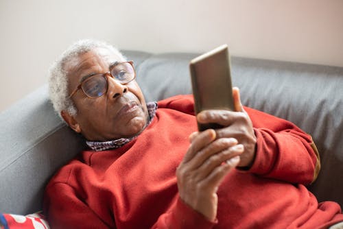 Free An Elderly Man with Eyeglasses Using His Cell Phone Stock Photo