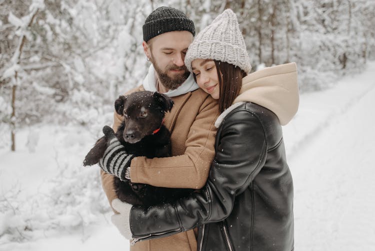 A Couple Hugging With Their Dog