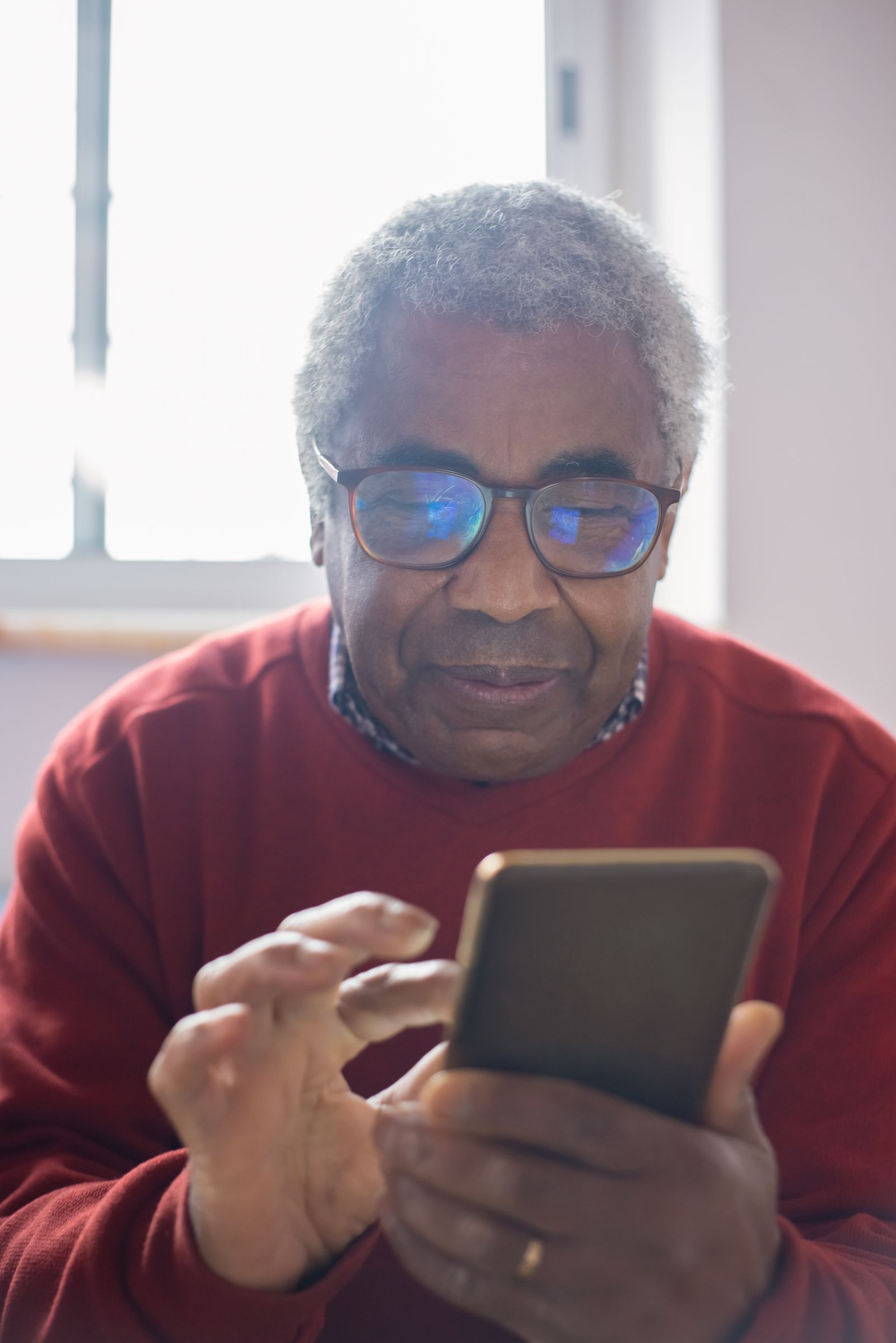 Personne âgée souriante utilisant un smartphone