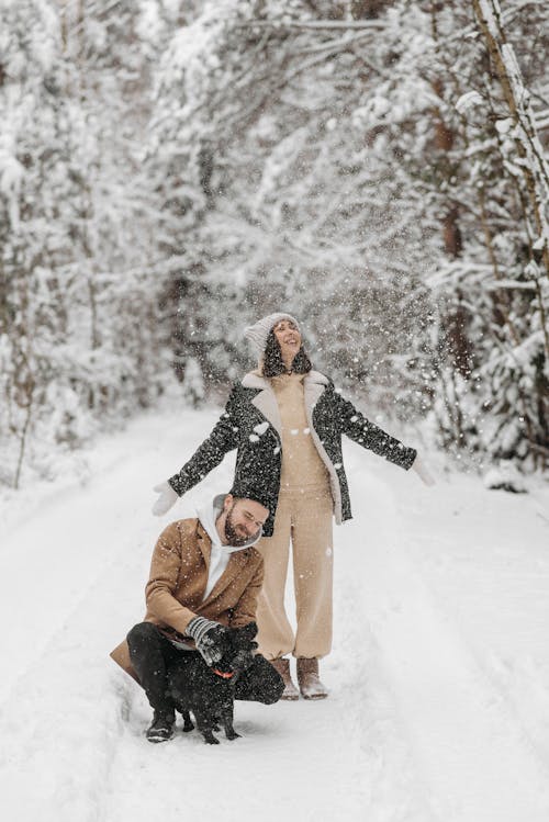 Free A Couple on Snow Covered Road with a Dog Stock Photo