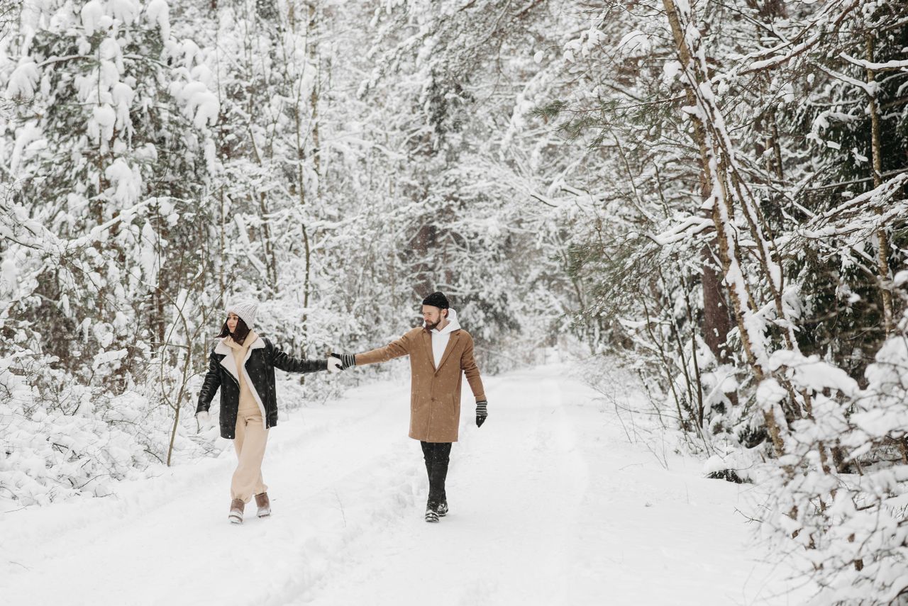 Couple holding hands walking on a snowy winter road