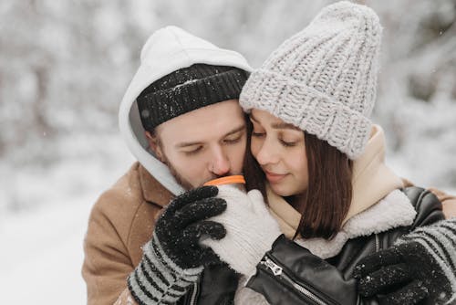 Free Photograph of a Man with a Black Knitted Cap Drinking Beside a Woman Stock Photo
