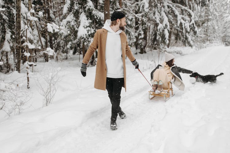 
A Man Pulling A Woman On A Sleigh