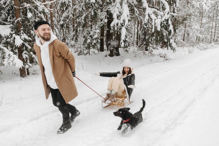 
A Man Pulling A Woman On A Sleigh