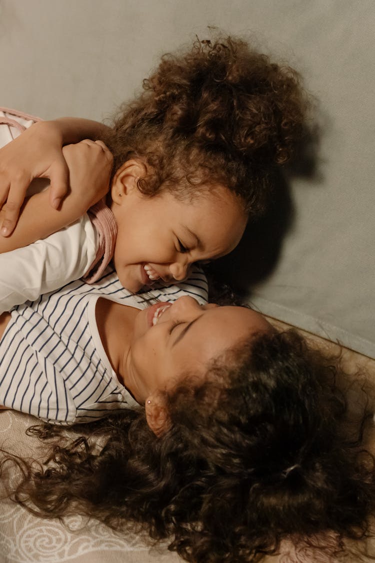 Photograph Of A Girl Smiling While Hugging Her Sibling