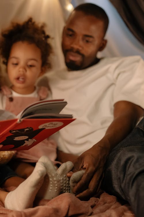 Free Photograph of a Father Reading a Book with His Daughter Stock Photo
