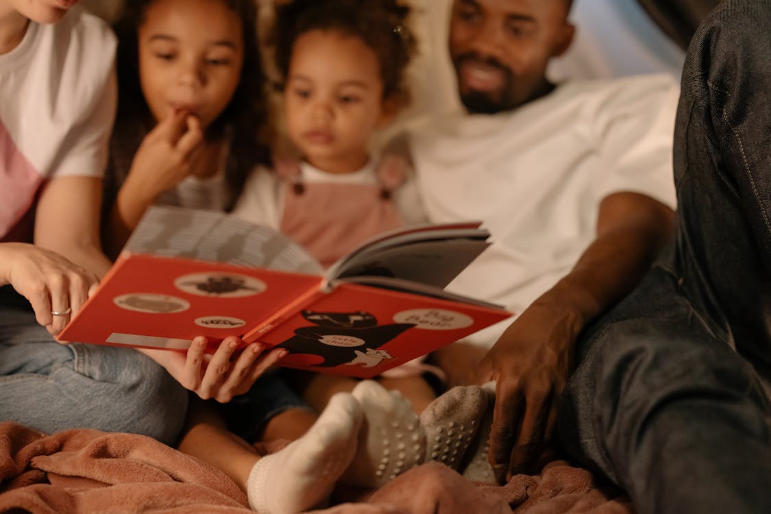 Parents Reading a Book to Their Children