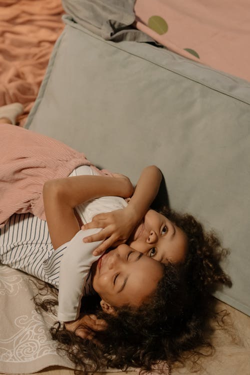 Free Photo of a Girl with Curly Hair Hugging Her Sister Stock Photo