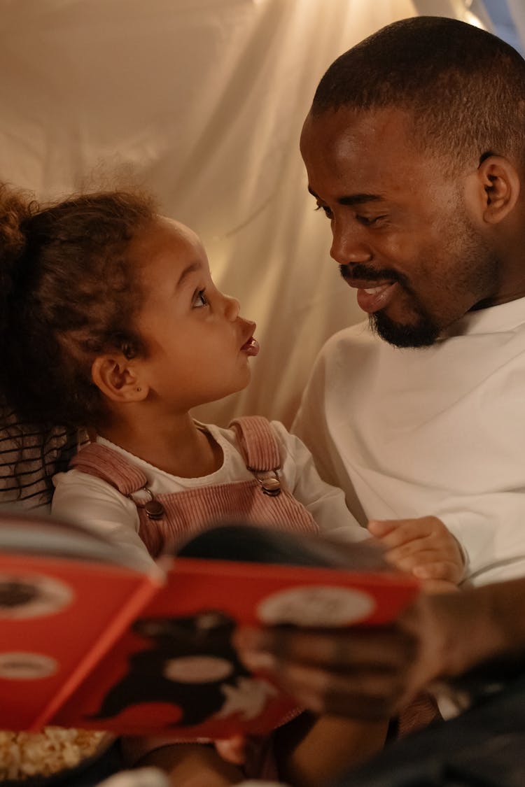 A Man Smiling While Looking At The Young Girl