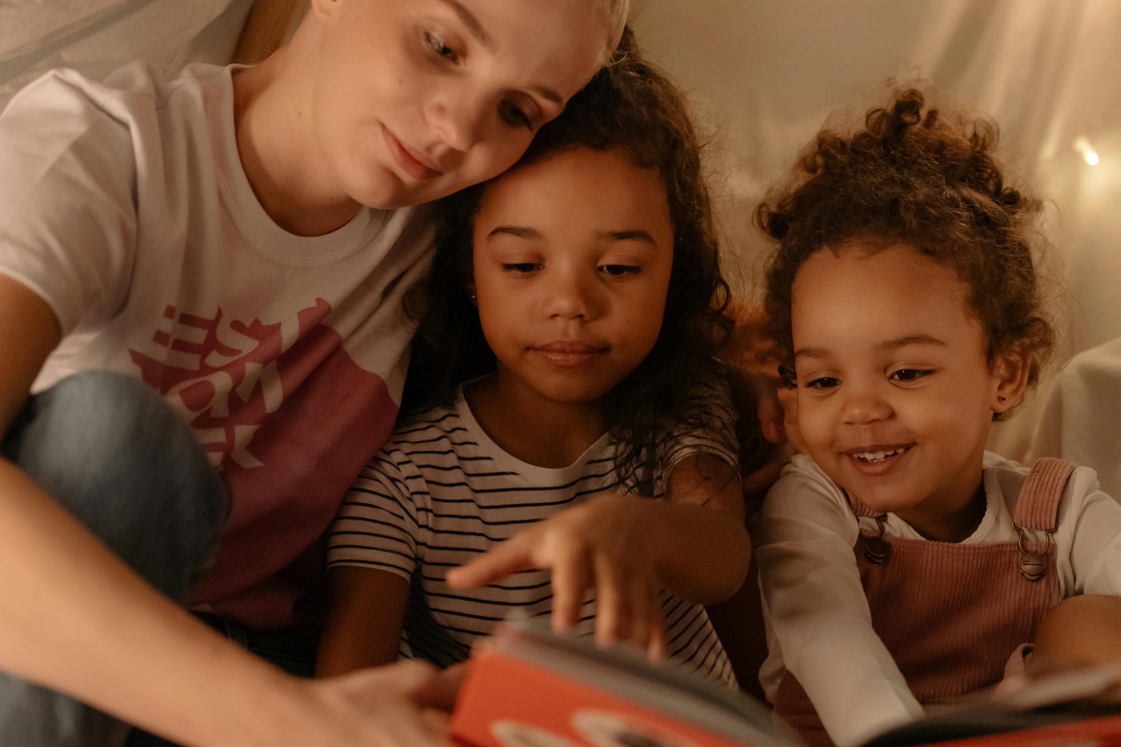 a woman reading a book with her daughters