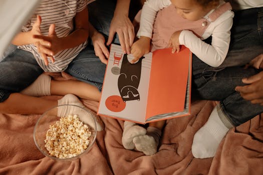 A diverse family enjoys reading together indoors with popcorn, capturing a cozy moment.