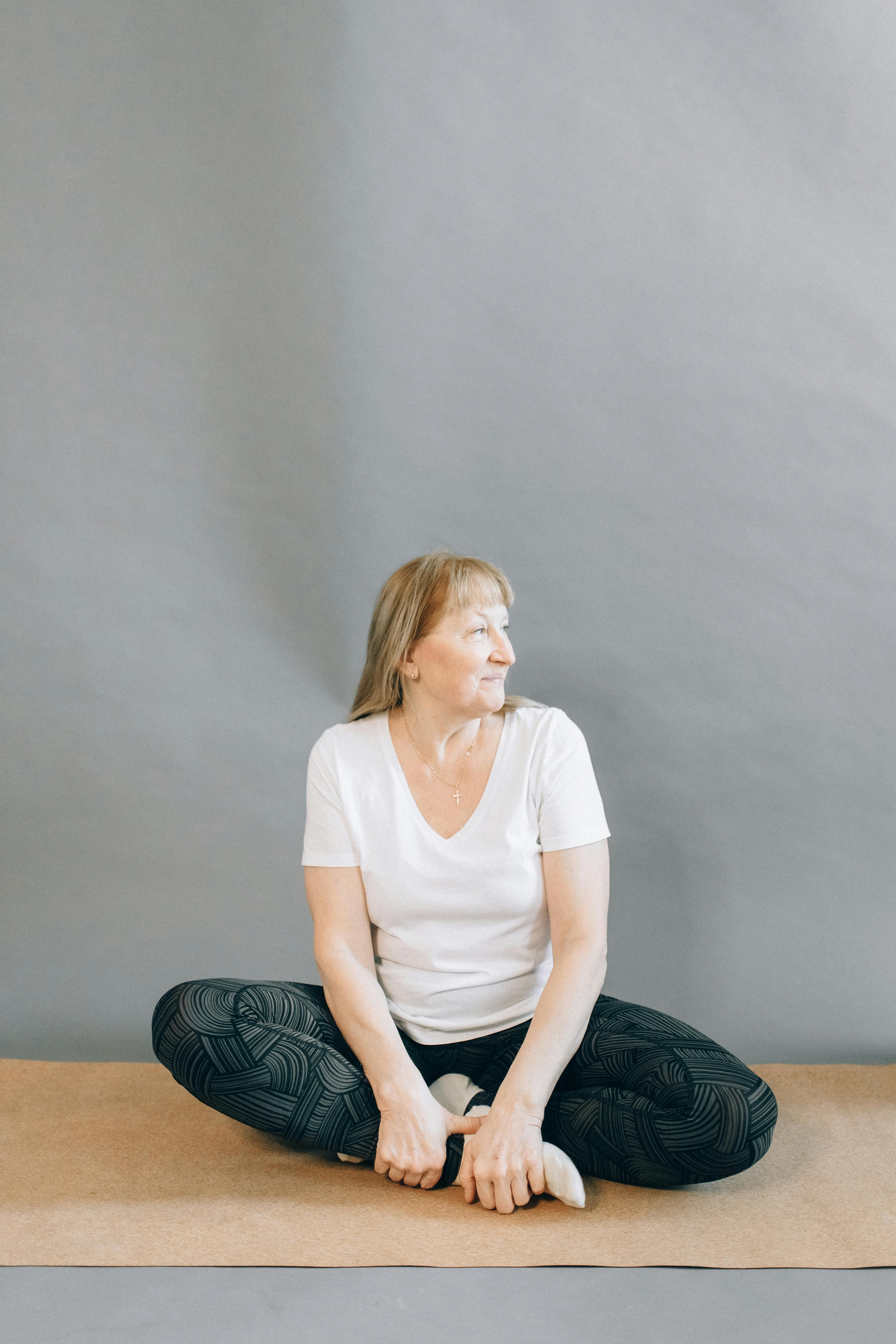 woman in white crew neck t shirt sitting on gray couch