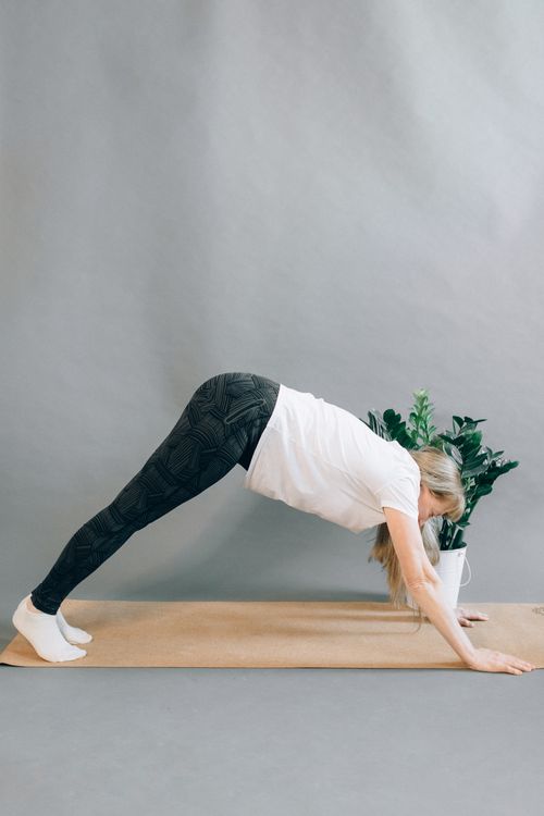 Free Woman performs yoga pose indoors on a mat for fitness and wellness. Stock Photo