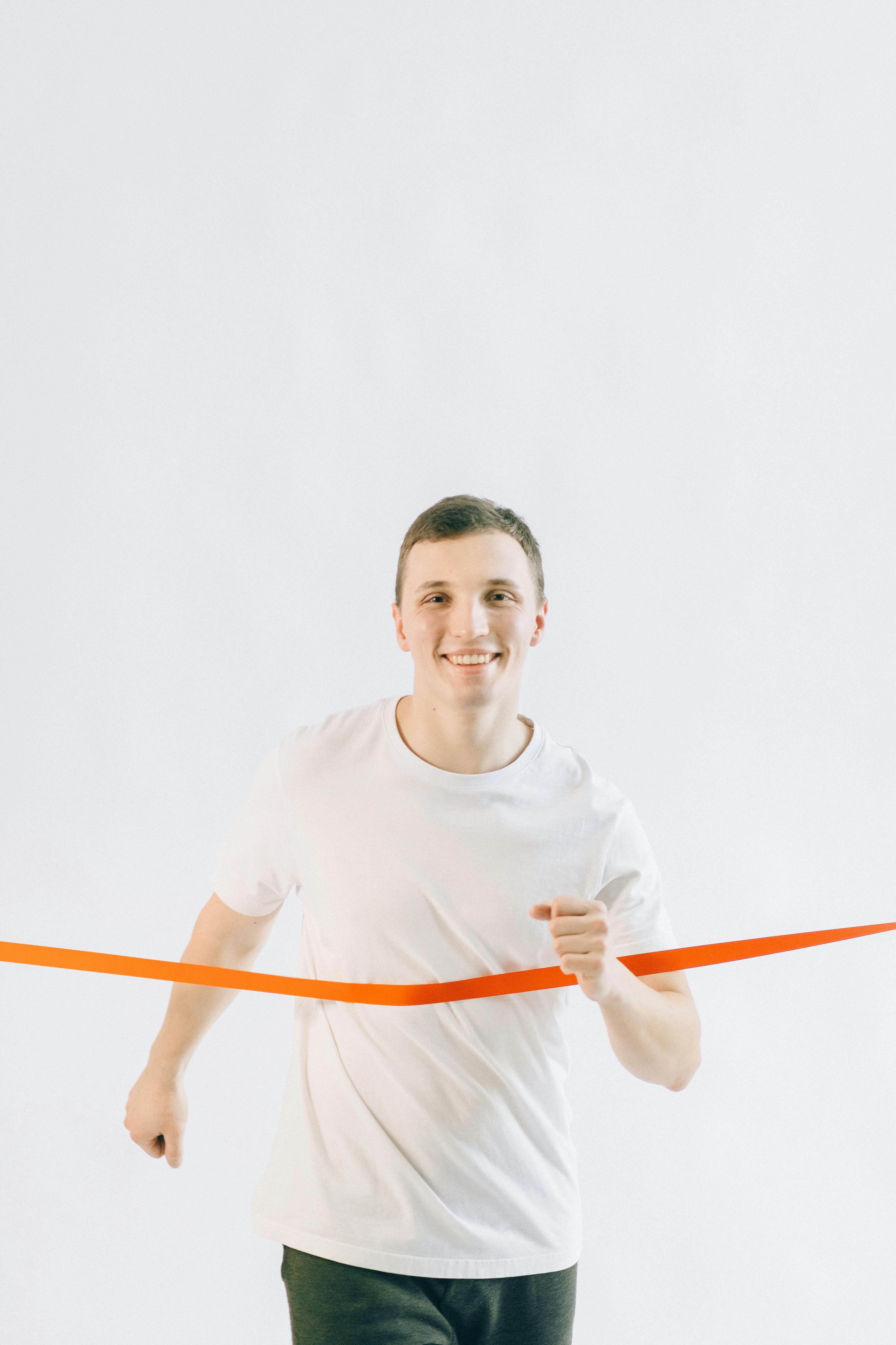 man in white crew neck t shirt holding red stick