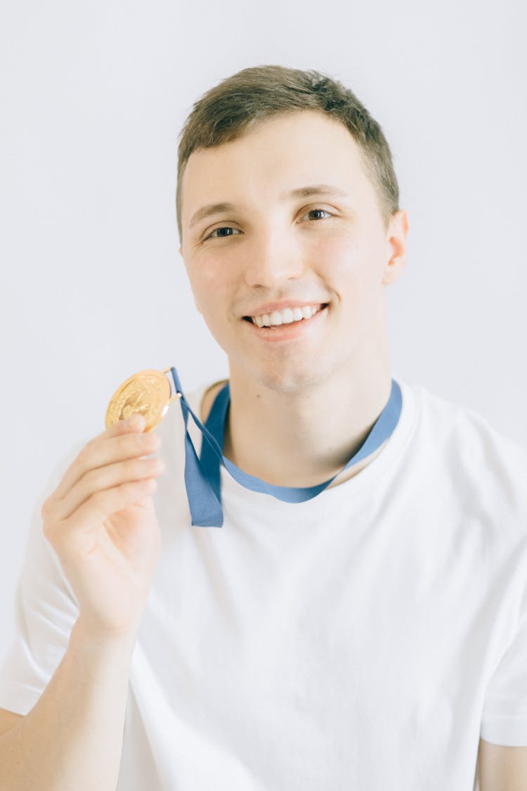 Young Man Holding A Gold Medal