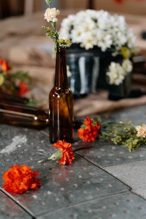 White and Red Flowers on Brown Glass Bottle