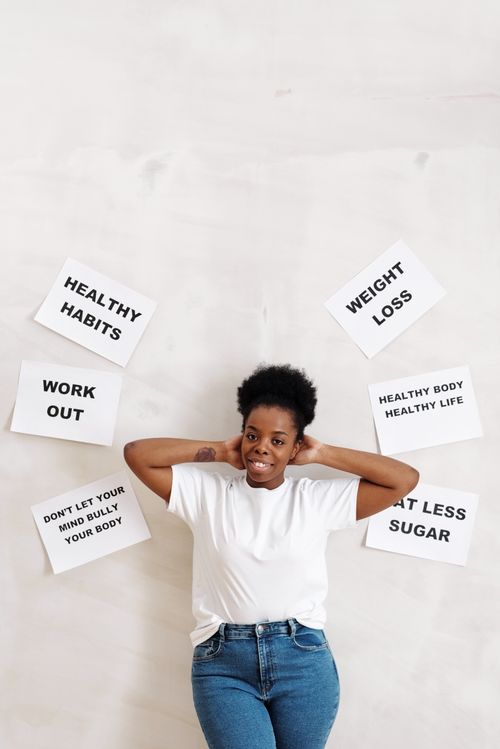 Free Woman standing against a wall with motivational slogans promoting health and fitness. Stock Photo