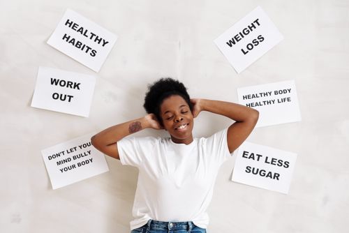 Free Smiling woman embracing positive lifestyle with healthy living messages around her. Stock Photo