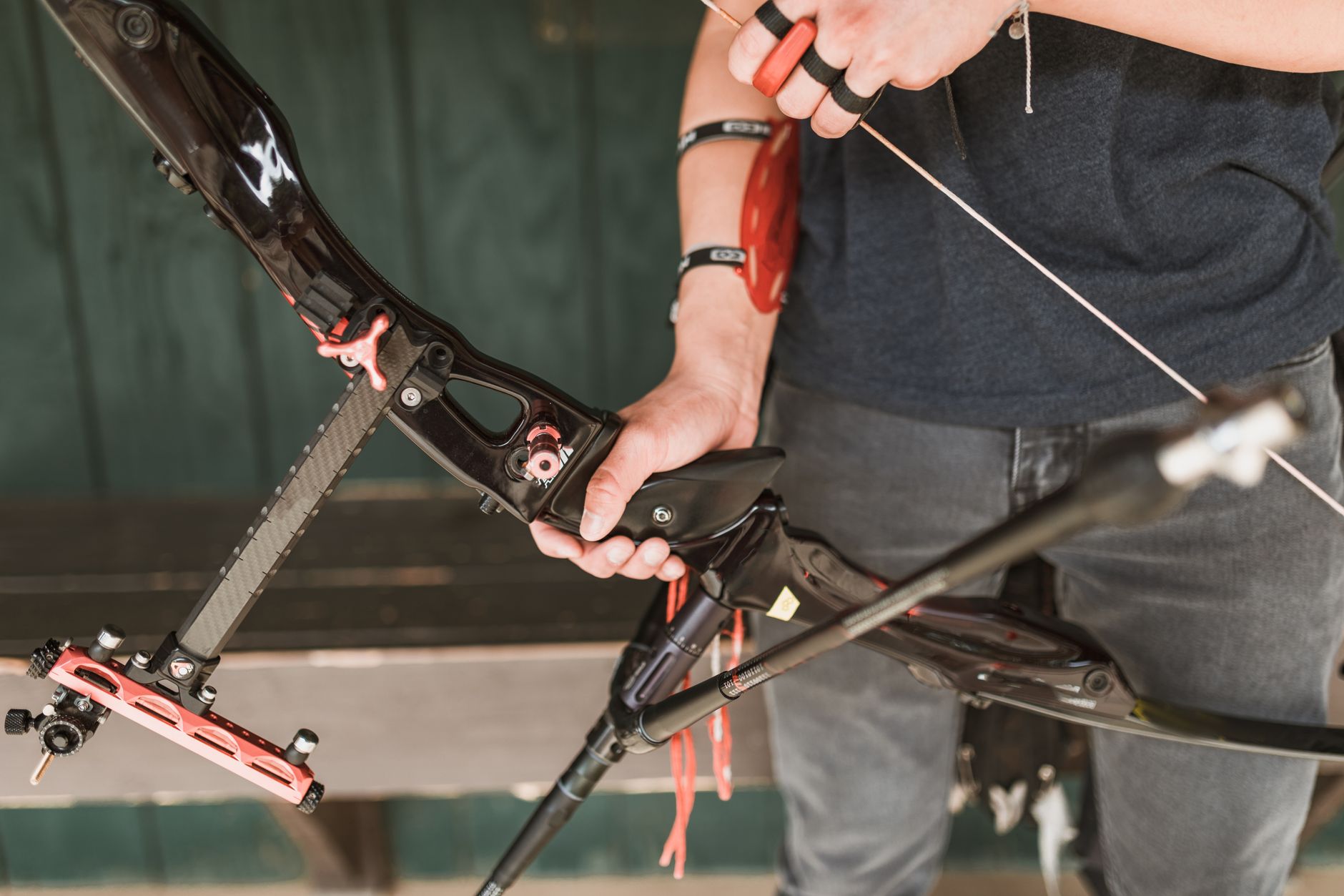 A focused archer preparing to shoot with a recurve bow, showcasing archery equipment.