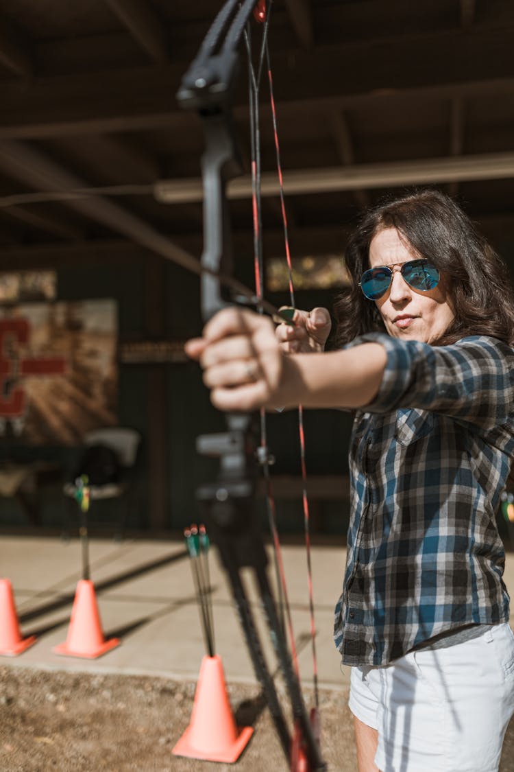 Woman Holding A Bow And Arrow And Aiming