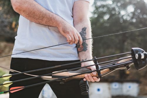 Free A man prepares for archery practice with a recurve bow, focusing on target archery skills. Stock Photo