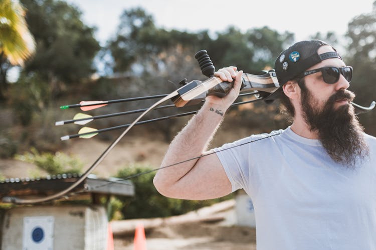 A Bearded Man Holding A Bow And Arrows