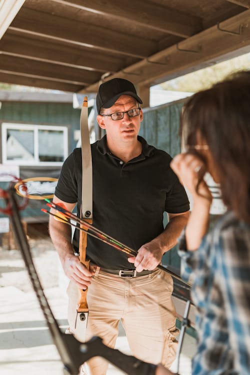 A Man Holding Bow and Arrows Next to a Woman