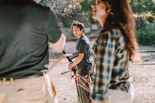 Free Group of young archers engaged in outdoor practice at an archery range, basking in sunlight. Stock Photo