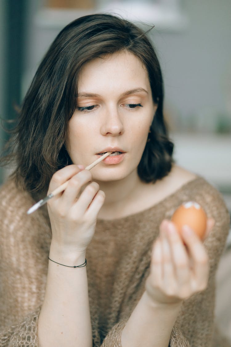 A Woman Holding A Brown Egg