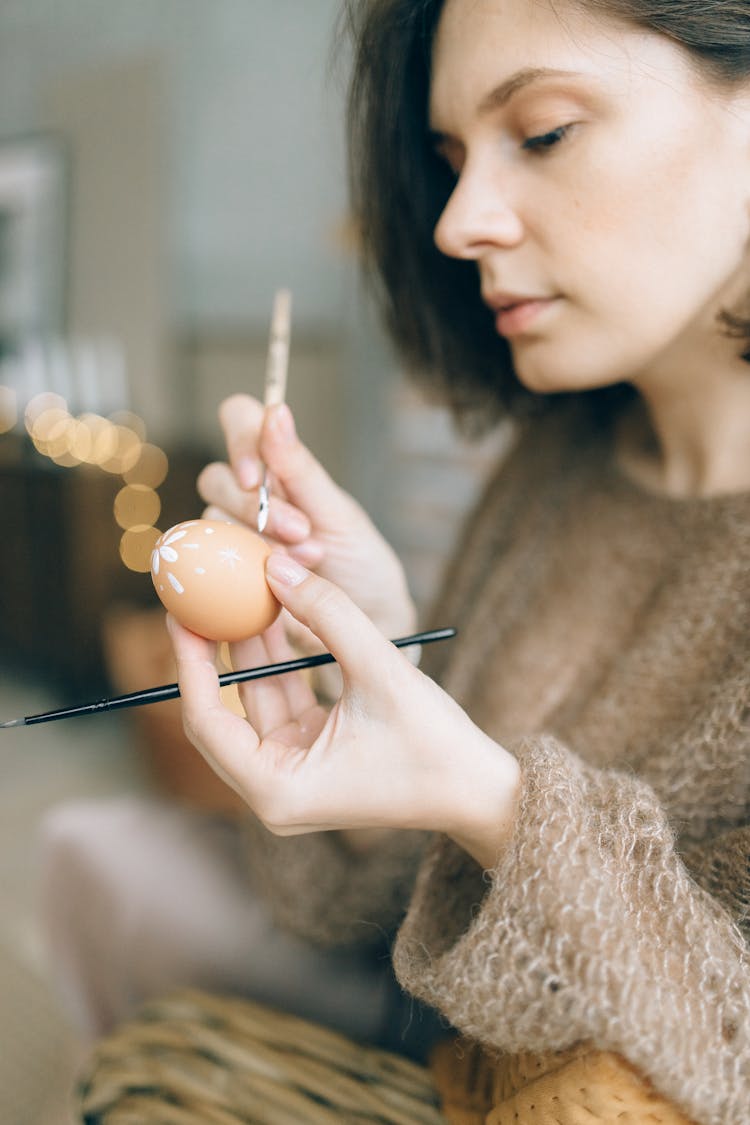 A Woman Painting A Brown Egg