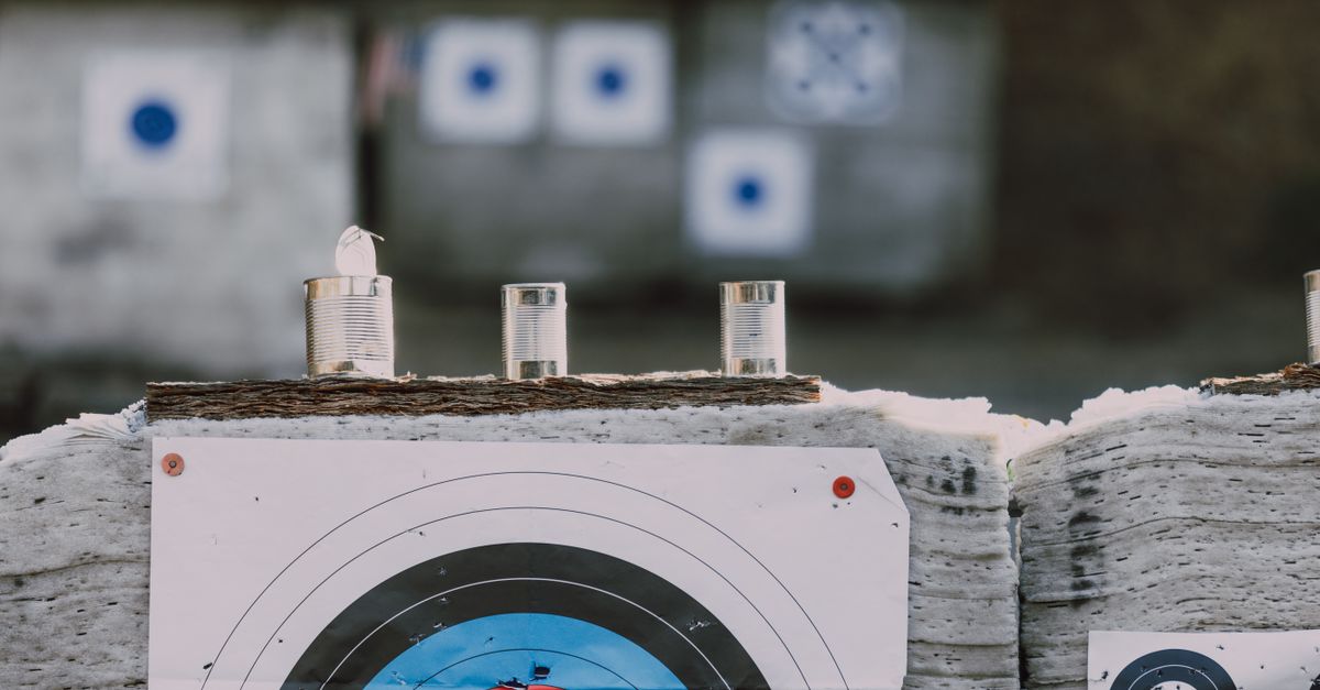 Close-up of archery targets and steel cans used for target practice at an outdoor range.