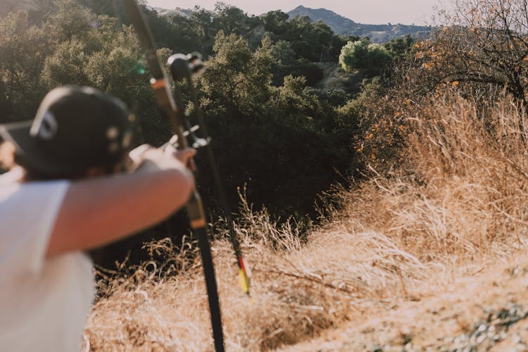 Person Holding A Bow Hunting In The Forest 