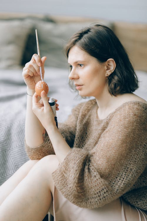 Free Woman Sitting on the Floor Painting an Egg Stock Photo