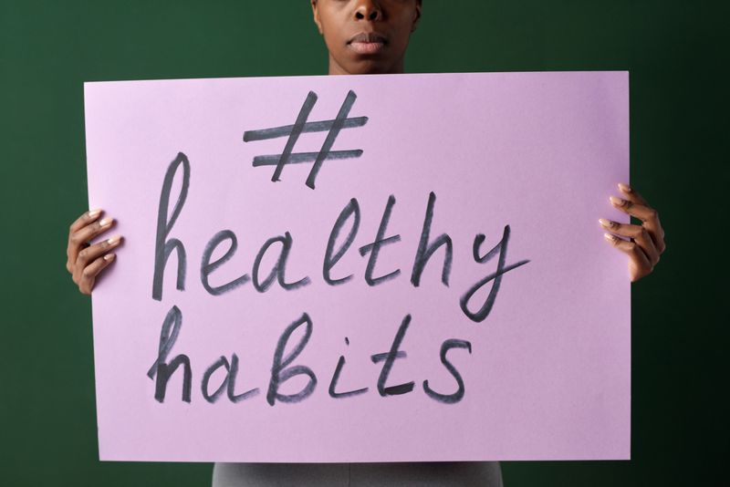 Person holding a healthy habits sign promoting wellness and self improvement