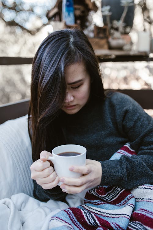 Free Sad Woman Holding a Cup of Coffee Stock Photo