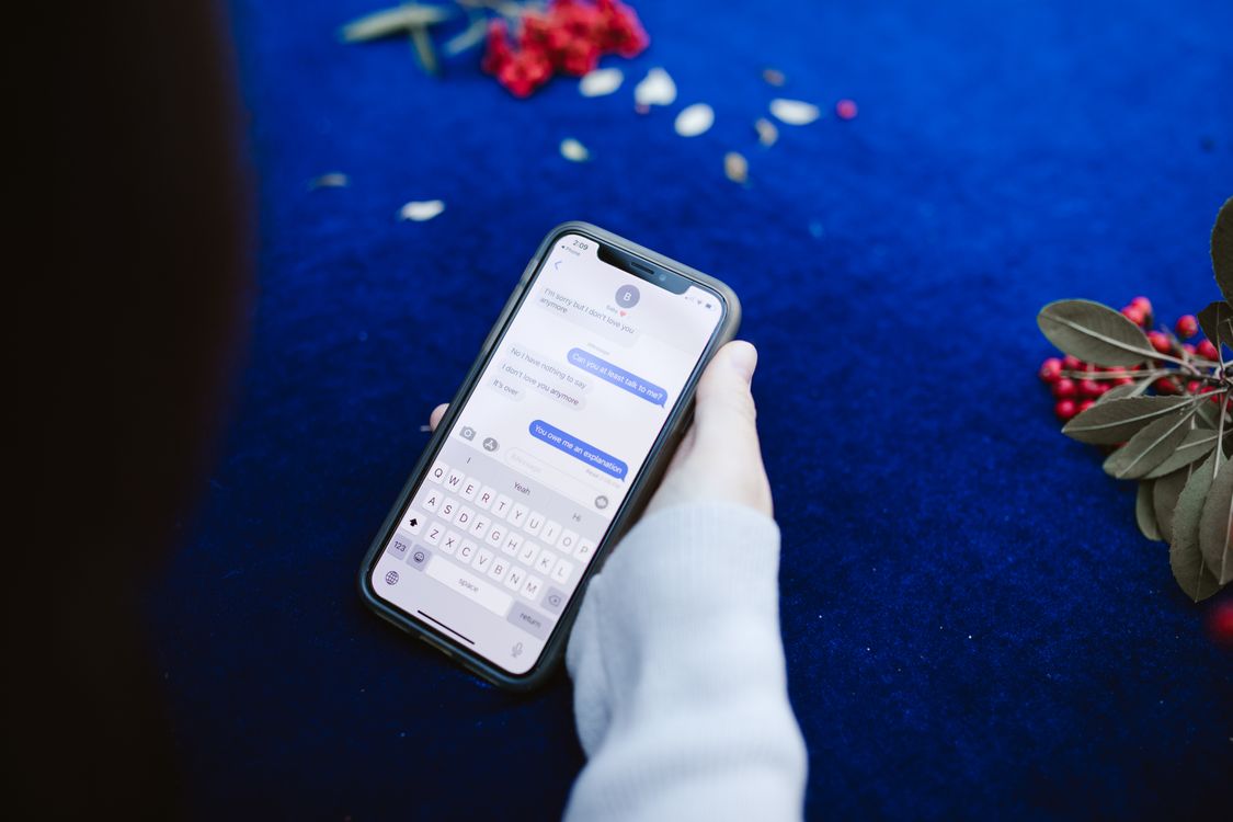 person holding smartphone displaying text messages