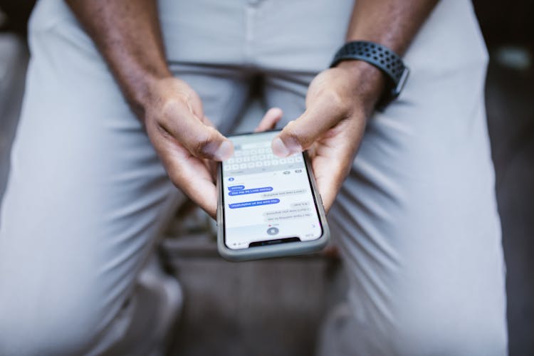 Man's Thumbs Typing On A Smartphone