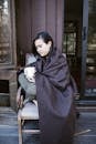 Woman Sitting on Wooden Chair Holding a Ceramic Mug