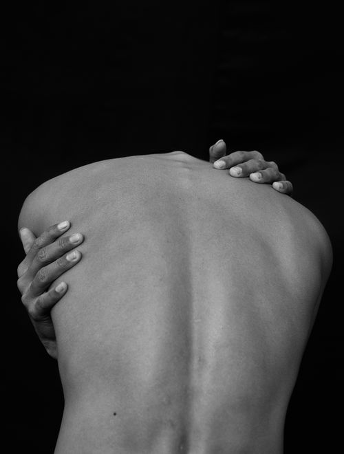 Free Black and white photograph of a shirtless person with hands on their back. Stock Photo