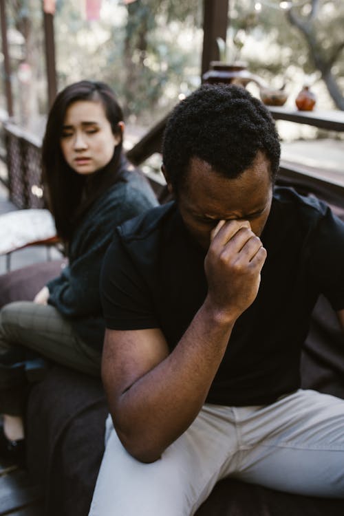 Free Woman Sitting Beside the Crying Man Stock Photo