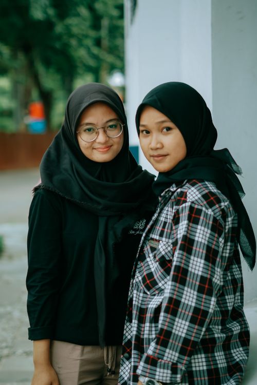 Free Two young Asian women wearing hijabs and smiling, standing outdoors in Cirebon, Indonesia. Stock Photo