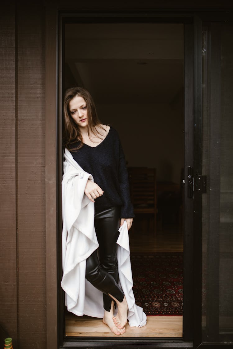 Woman In Black Sweater Leaning On The Doorway