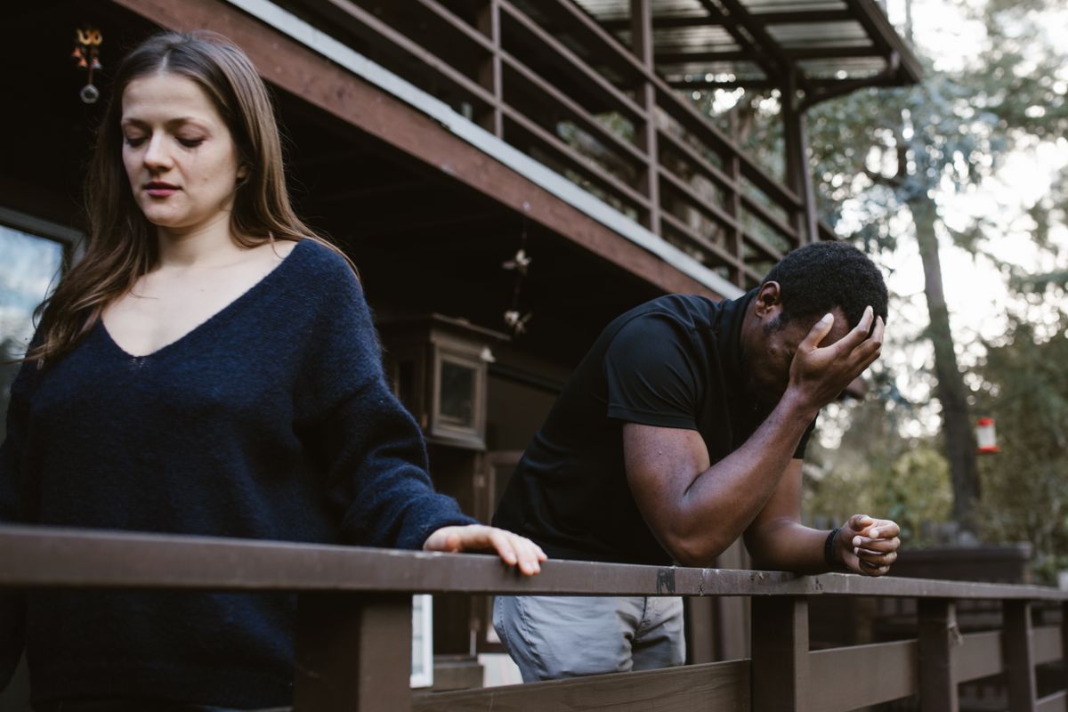 Vrouw die wegloopt terwijl de man het hoofd in de handen heeft